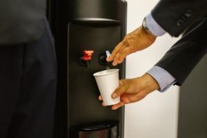 Παροχή πόσιμου νερού από ψύκτη γραφείου σε χάρτινο ποτήρι